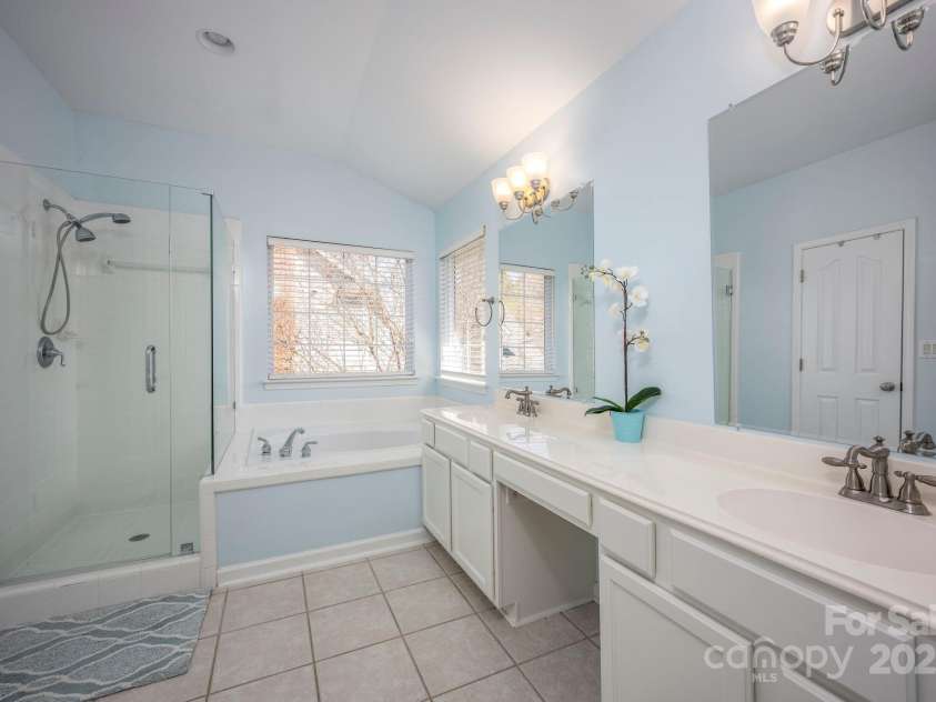 3329 Brownes Creek Road, Charlotte, NC 28269.  MLS# CAR4232626, YatesRealty ID 2790. Primary bath with dual vanities, soaking tub and walk in shower with new seamless glass surround
