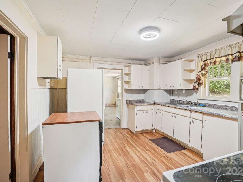 203 Beaverdam Road, Candler, NC 28715.  MLS# CAR4282589, YatesRealty ID 27973. Kitchen leading to flex room