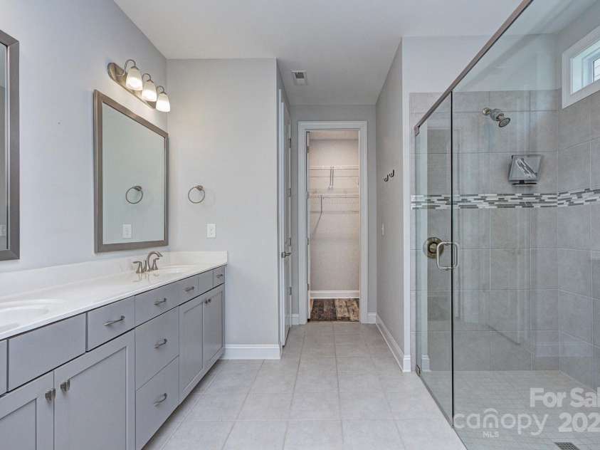 5527 Cheerful Lane, Charlotte, NC 28215.  MLS# CAR4275434, YatesRealty ID 28049. Framed mirrors over sinks remain, tiled flooring, extended shower with tiled shower pan