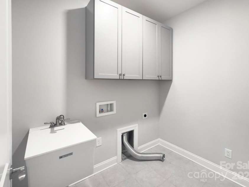5527 Cheerful Lane, Charlotte, NC 28215.  MLS# CAR4275434, YatesRealty ID 28049. Laundry room- tile flooring, cabinets for extra storage, utility sink with cover