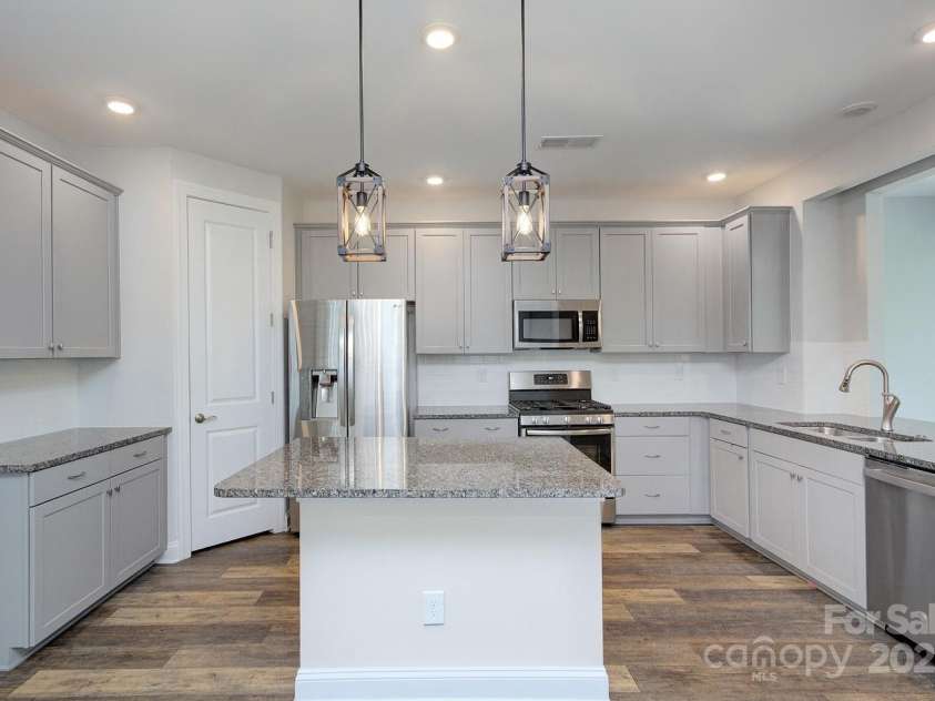 5527 Cheerful Lane, Charlotte, NC 28215.  MLS# CAR4275434, YatesRealty ID 28049. Sland with storage, roll out trash bin, extended bar for extra seating-fits 2 bar stools easily.  Gas stove, dishwasher, built in microwave and walk in pantry. refrigerator is negotiable