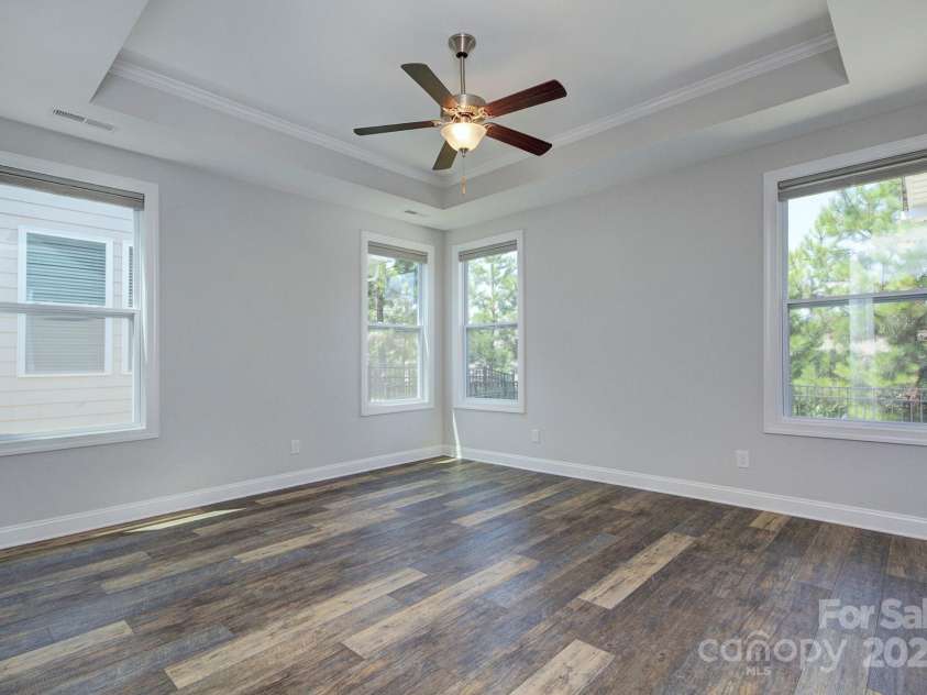 5527 Cheerful Lane, Charlotte, NC 28215.  MLS# CAR4275434, YatesRealty ID 28049. Spacious primary bedroom- extra windows for great  natural light, trey ceiling with molding and ceiling fan