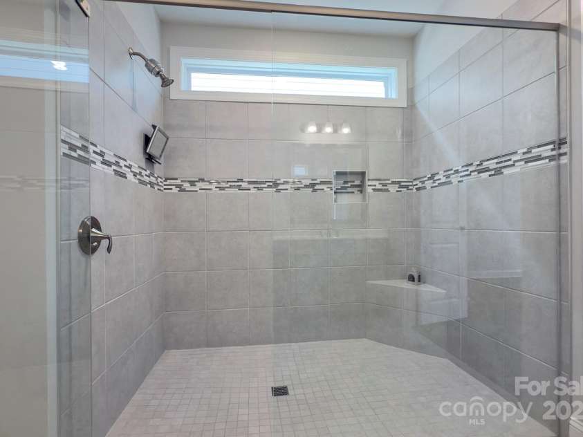 5527 Cheerful Lane, Charlotte, NC 28215.  MLS# CAR4275434, YatesRealty ID 28049. Transom offers natural lighting, large shower with corner bench, niche for bath products, roll right in!