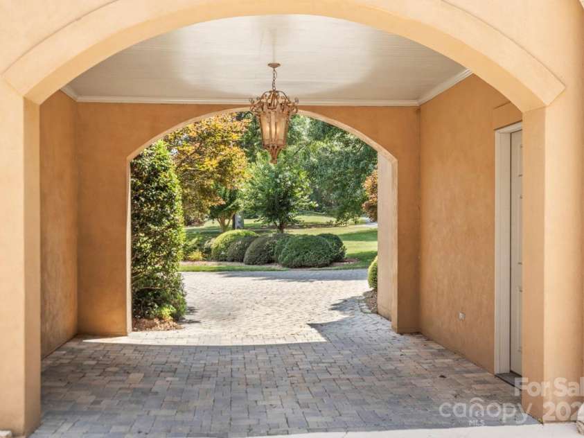 343 Wester Brewlands Road, Iron Station, NC 28080.  MLS# CAR4284507, YatesRealty ID 28060. A charming portico welcomes you with a graceful lantern-style fixture and cobblestone drive, setting the tone for timeless elegance as you transition between indoor luxury and the estate’s manicured grounds