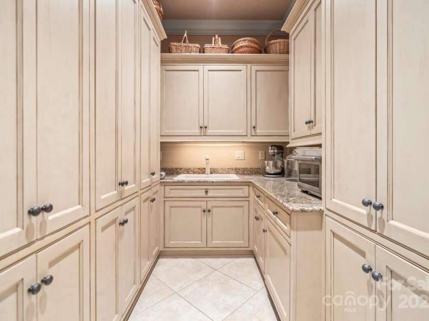 343 Wester Brewlands Road, Iron Station, NC 28080.  MLS# CAR4284507, YatesRealty ID 28060. A Chef's Dream Pantry! Thoughtfully designed walk-in pantry with abundant custom cabinetry, granite countertops, 2nd dishwasher and a prep sink—perfect for storing, staging, and seamlessly supporting everyday 