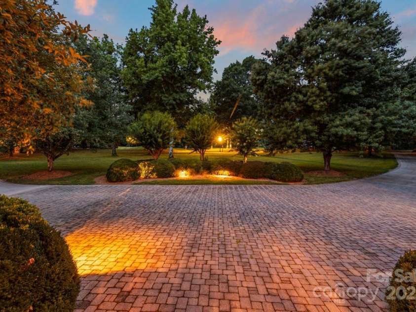 343 Wester Brewlands Road, Iron Station, NC 28080.  MLS# CAR4284507, YatesRealty ID 28060. A Grand Arrival, A Lasting Impression! As you step outside the front entry, you're met with a breathtaking view of the circular paver drive, perfectly framed by professionally lit landscaping and mature trees.