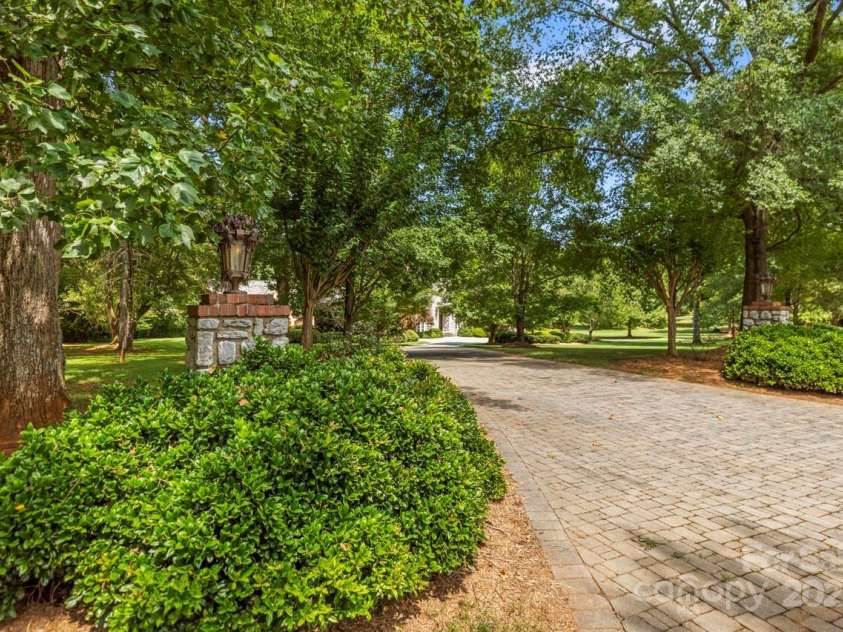 343 Wester Brewlands Road, Iron Station, NC 28080.  MLS# CAR4284507, YatesRealty ID 28060. A Grand Welcome Begins Here! A stately circular drive winds beneath a canopy of mature trees, welcoming you with manicured landscaping and custom stone columns. This picture-perfect approach sets the tone for 