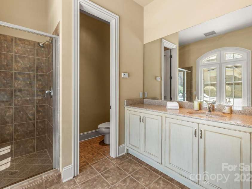 343 Wester Brewlands Road, Iron Station, NC 28080.  MLS# CAR4284507, YatesRealty ID 28060. The pool house interior offers a full bath with tile shower, large vanity, and private water closet—perfect for guest comfort during outdoor gatherings. An adjacent equipment room keeps the mechanical systems 