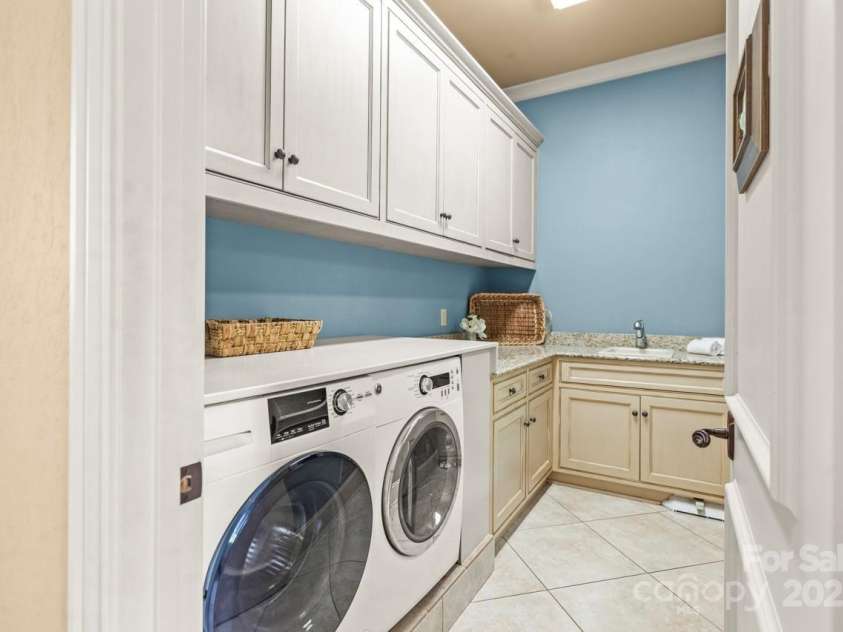 343 Wester Brewlands Road, Iron Station, NC 28080.  MLS# CAR4284507, YatesRealty ID 28060. Thoughtful details behind every door! This oversized laundry room features extensive cabinetry, granite countertops, and a built-in dog washing station—a rare and thoughtful upgrade! A discreet dog door adds e