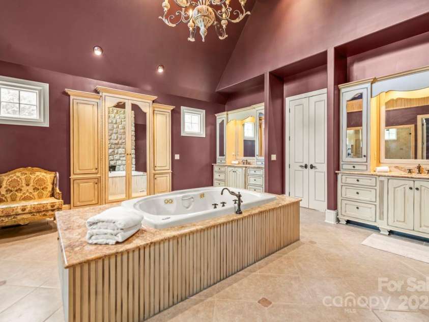 343 Wester Brewlands Road, Iron Station, NC 28080.  MLS# CAR4284507, YatesRealty ID 28060. Thoughtful hand made details! Open the mirrors to reveal a hidden vanity. His-and-hers vanities are separated by a central linen tower and flanked by custom mirrors and lighting, offering function with refined
