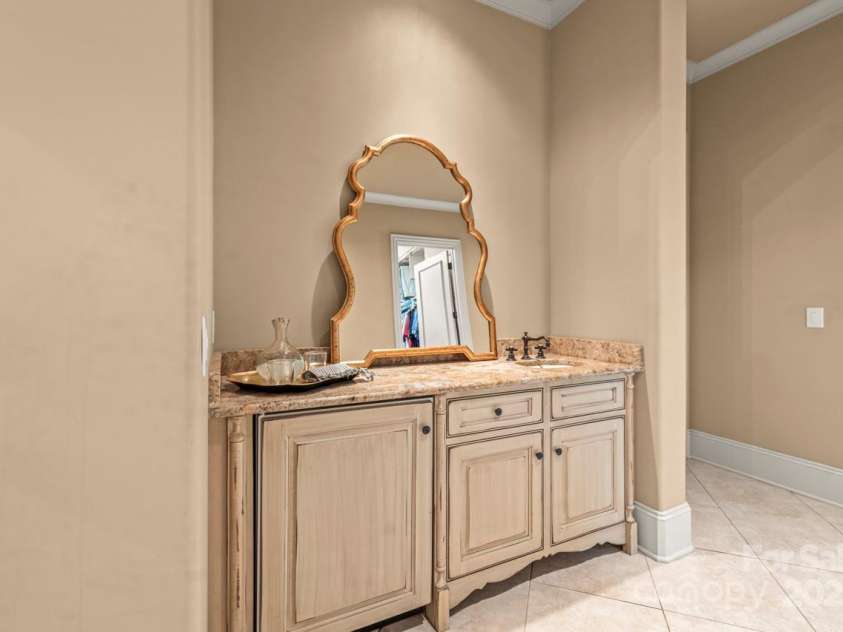 343 Wester Brewlands Road, Iron Station, NC 28080.  MLS# CAR4284507, YatesRealty ID 28060. Wake Up in Luxury! Thoughtfully tucked into the primary wing, this elegant coffee bar features a beverage fridge and custom cabinetry. The rounded wall corners and softly arched architecture echo the sophistic