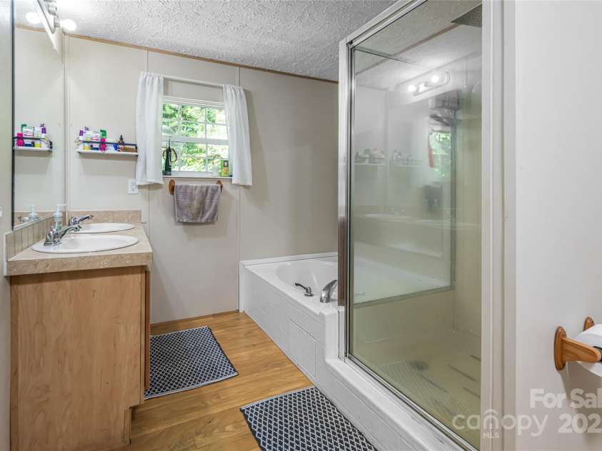 118 Reeves Road, Leicester, NC 28748.  MLS# CAR4280942, YatesRealty ID 28083. Primary bath with garden tub, dual sinks, walk in shower, large walk-in closet