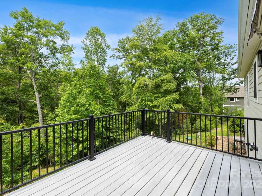 73 Wisdom Cove Road, Flat Rock, NC 28731.  MLS# CAR4203764, YatesRealty ID 28093. Back deck overlooking yard and large wooded area down to the creek
