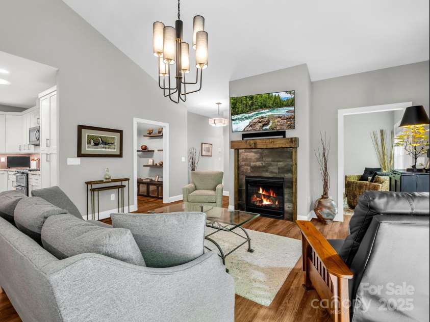 29 Stonehollow Lane, Brevard, NC 28712.  MLS# CAR4282263, YatesRealty ID 28142. Natural gas fireplace in living room with vaulted ceilings, natural light and open floor plan