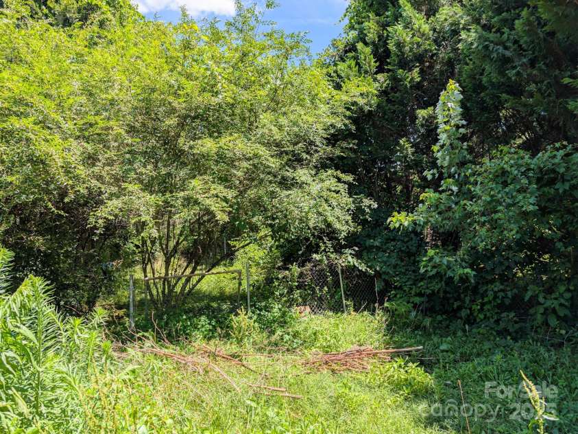 59 Poteat Street, Fletcher, NC 28732.  MLS# CAR4277892, YatesRealty ID 28173. An old fence surrounds the old back yard.