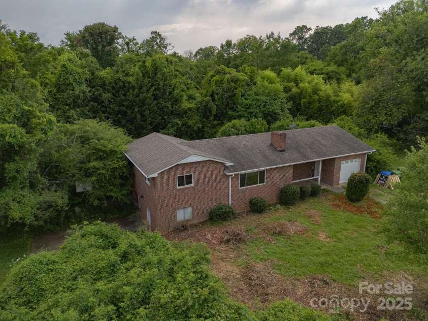 59 Poteat Street, Fletcher, NC 28732.  MLS# CAR4277892, YatesRealty ID 28173. The brown brush used to be weeds that recently got removed.