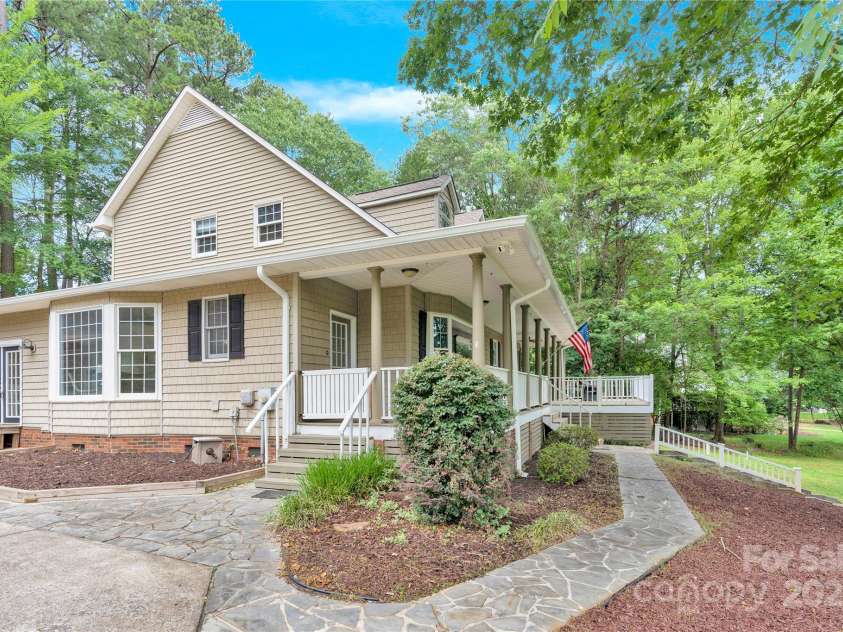 832 Kemp Road, Mooresville, NC 28117.  MLS# CAR4264266, YatesRealty ID 28181. Front of home, side view from driveway. Bay window shown, wrap around porch and stone walkway.