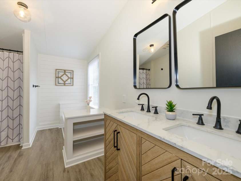 4833 Verde View Drive, Gastonia, NC 28056.  MLS# CAR4276387, YatesRealty ID 28190. Relax in your primary bath enclave! New dual sink vanity , countertops, farmhouse mirrors, walk in shower and custom ship lap surrounded bath tub.