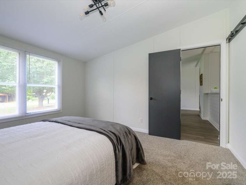 4833 Verde View Drive, Gastonia, NC 28056.  MLS# CAR4276387, YatesRealty ID 28190. Third view of primary bedroom with back to board and batten wall looking out to living area.
