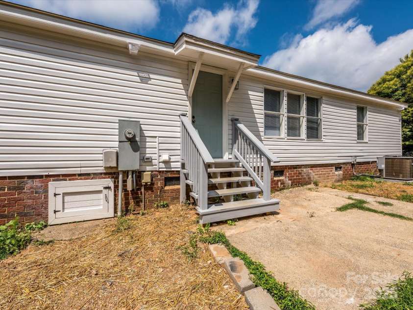 4833 Verde View Drive, Gastonia, NC 28056.  MLS# CAR4276387, YatesRealty ID 28190. View of rear steps and concrete patio slab in backyard.