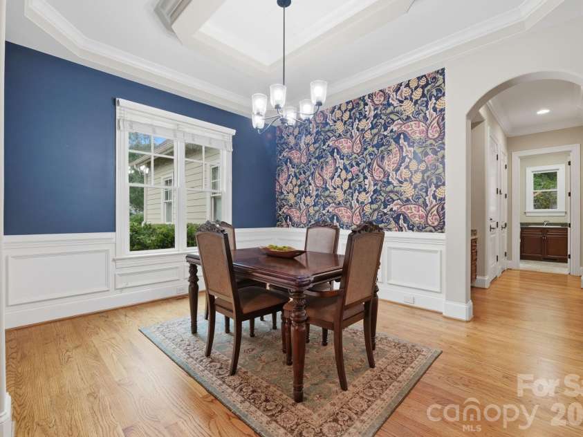 184 Ashmore Circle, Troutman, NC 28166.  MLS# CAR4384807, YatesRealty ID 28237. Elegant dining room featuring a tray ceiling, detailed millwork, and designer accent wall.