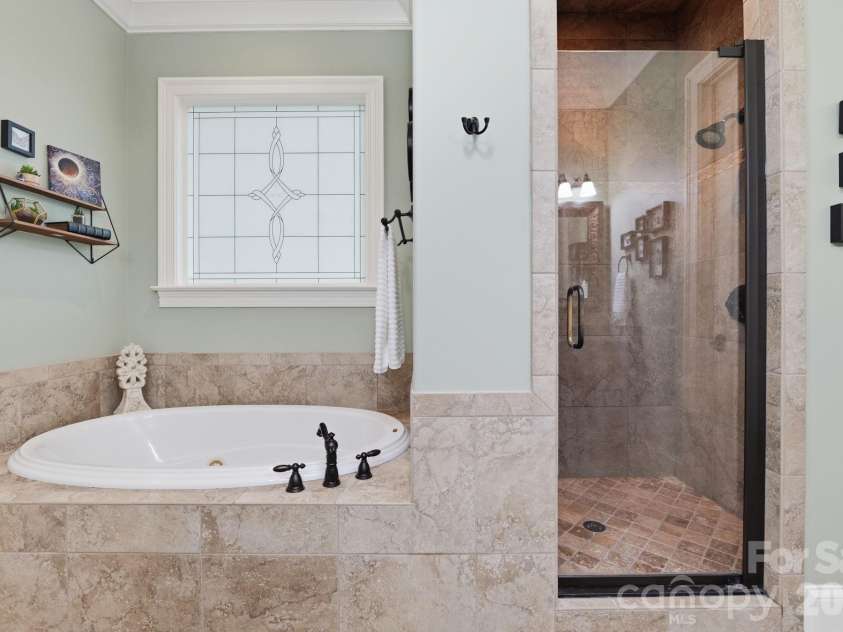 184 Ashmore Circle, Troutman, NC 28166.  MLS# CAR4384807, YatesRealty ID 28237. Spa-inspired primary bath featuring a relaxing soaking tub and oversized tiled walk-in shower.