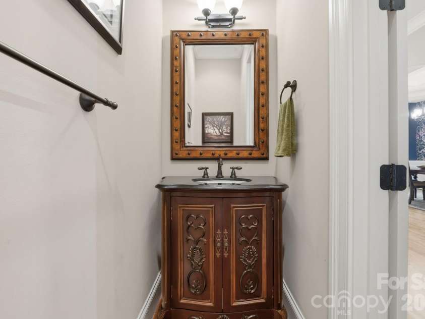 184 Ashmore Circle, Troutman, NC 28166.  MLS# CAR4384807, YatesRealty ID 28237. Stylish main-level powder room with custom vanity and decorative mirror.