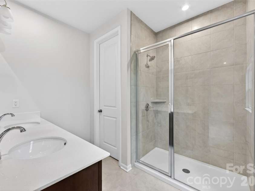 6021 Longar Lane, Charlotte, NC 28269.  MLS# CAR4376915, YatesRealty ID 28240. Dual vanity primary bathroom with walk-in shower