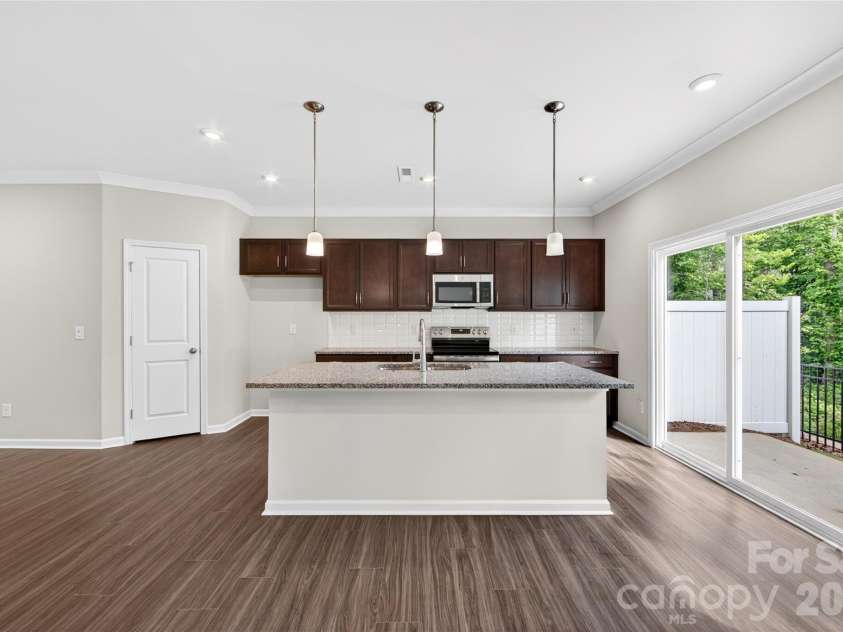 6021 Longar Lane, Charlotte, NC 28269.  MLS# CAR4376915, YatesRealty ID 28240. Kitchen with brown cabinets and Caledonia Granite countertops