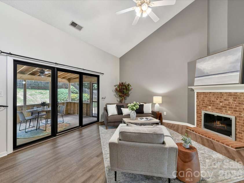 9518 Cedar River Road, Huntersville, NC 28078.  MLS# CAR4381514, YatesRealty ID 28268. Spacious great room features soaring vaulted ceilings, updated flooring, and a cozy fireplace, creating an open and inviting space perfect for relaxing or entertaining.
