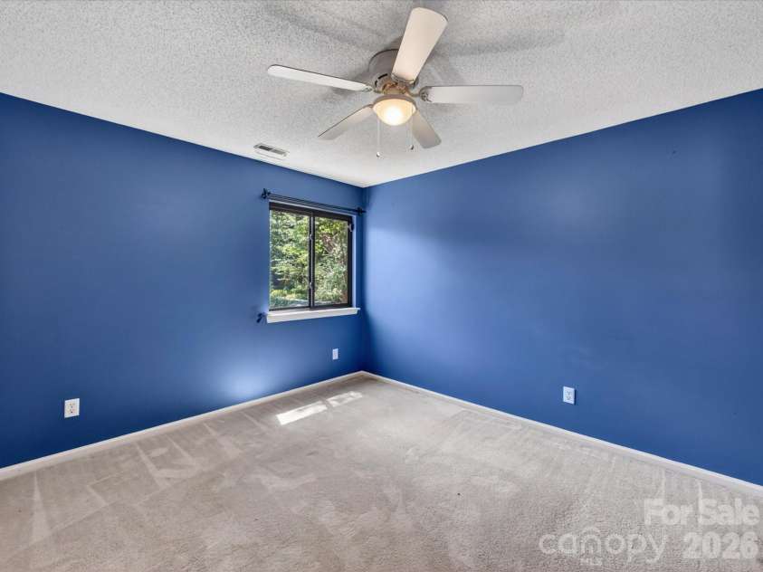 9518 Cedar River Road, Huntersville, NC 28078.  MLS# CAR4381514, YatesRealty ID 28268. Spacious secondary bedroom features fresh neutral carpeting, ceiling fan, generous closet space, and abundant natural light, creating a comfortable and versatile retreat for family or guests.