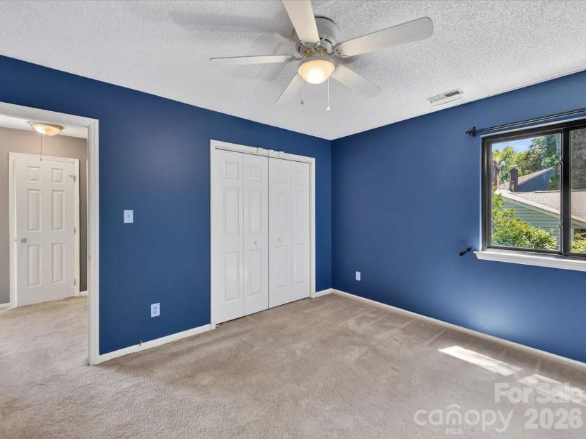 9518 Cedar River Road, Huntersville, NC 28078.  MLS# CAR4381514, YatesRealty ID 28268. Spacious secondary bedroom features fresh neutral carpeting, ceiling fan, generous closet space, and abundant natural light, creating a comfortable and versatile retreat for family or guests.