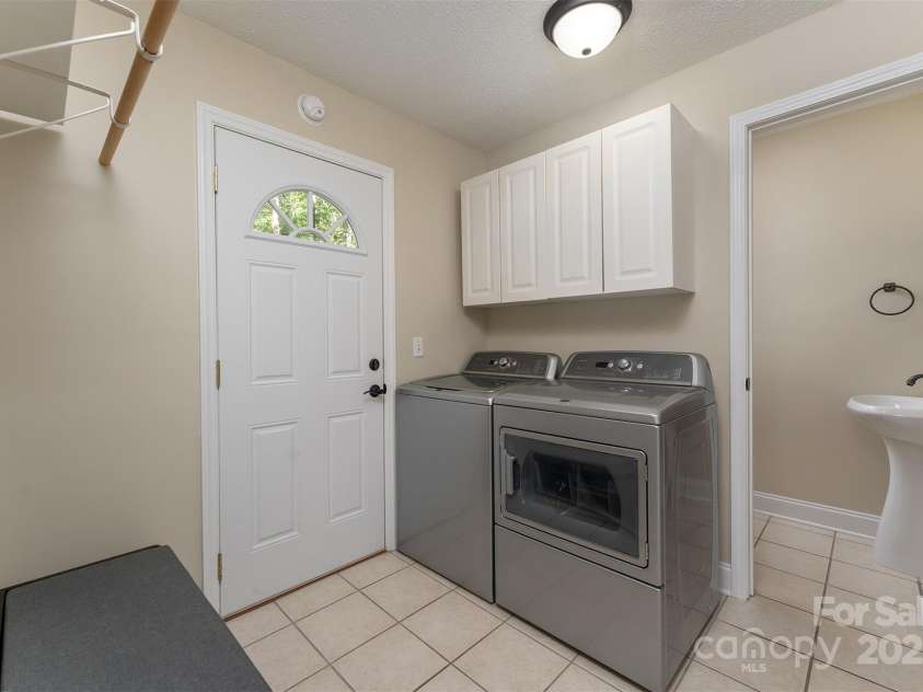 22 Glen Cove Road, Arden, NC 28704.  MLS# CAR4272199, YatesRealty ID 28269. The laundry room/mudroom with access to the back deck, a half bath, and the garage.