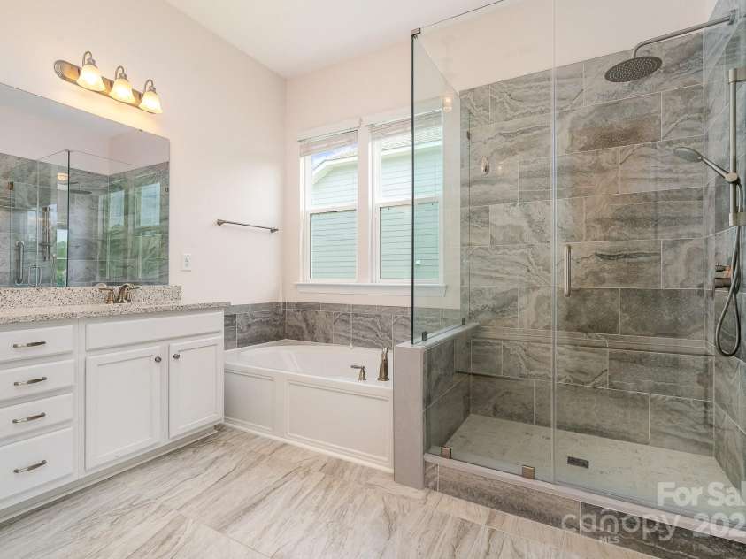 10016 St Kitts Landing Lane, Charlotte, NC 28278.  MLS# CAR4261578, YatesRealty ID 28282. Primary bath with large tiled shower, tub, and dual quartz vanity