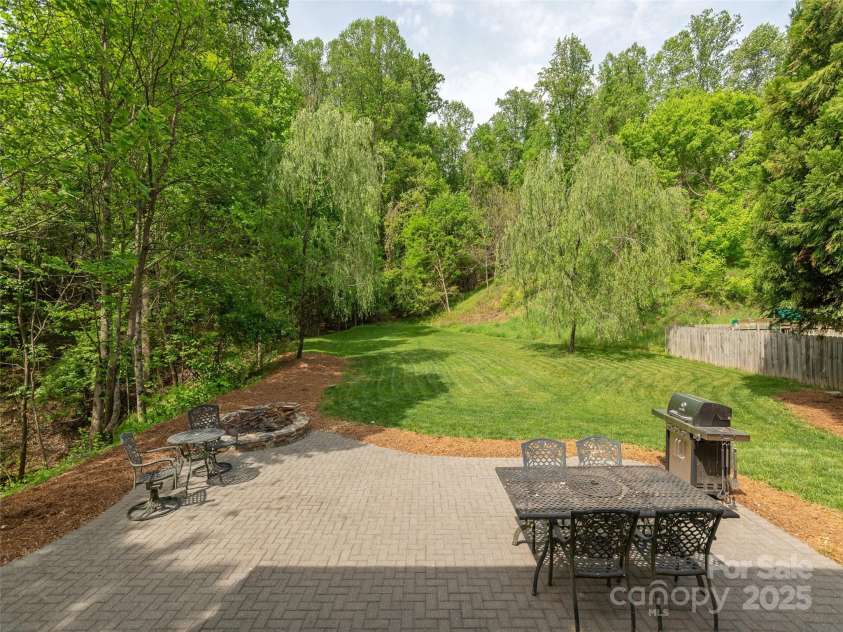 15 Dansford Lane, Arden, NC 28704.  MLS# CAR4255173, YatesRealty ID 28347. One of a kind firepit designed for the seller. Perfect for intimate settings or social gatherings...check out that lawn and weeping willow trees...