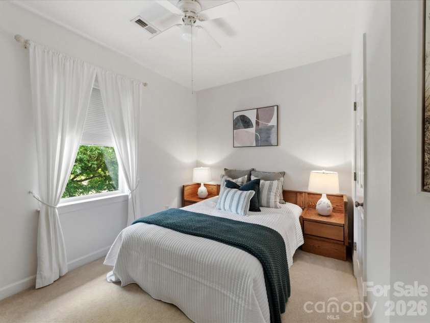 8611 Covedale Crossings Circle, Cornelius, NC 28031.  MLS# CAR4378956, YatesRealty ID 28395. Bright and inviting secondary bedroom features vaulted ceilings, plush carpeting, and abundant natural light, creating a comfortable retreat for guests or family.