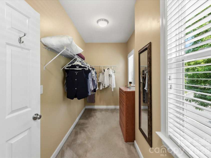 8611 Covedale Crossings Circle, Cornelius, NC 28031.  MLS# CAR4378956, YatesRealty ID 28395. Spacious walk-in primary closet offers ample storage, functional organization, and abundant natural light for added convenience and style.