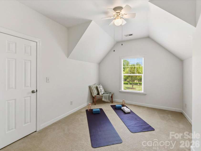 8611 Covedale Crossings Circle, Cornelius, NC 28031.  MLS# CAR4378956, YatesRealty ID 28395. Versatile secondary bedroom features vaulted ceilings, abundant natural light, plush carpeting, and flexible space ideal for guests, a playroom, or home gym.