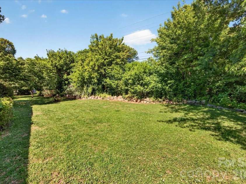 4330 Brookfield Drive, Charlotte, NC 28210.  MLS# CAR4383464, YatesRealty ID 28403. Gorgeous rock wall with buffer screening planting from Sharon Road