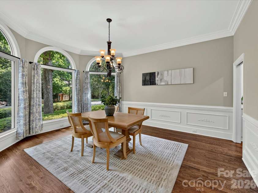4725 Old Course Drive, Charlotte, NC 28277.  MLS# CAR4384171, YatesRealty ID 28405. The elegant formal dining room features soaring ceilings, beautiful arched windows, abundant natural light, and serene views, creating a sophisticated setting for memorable gatherings.