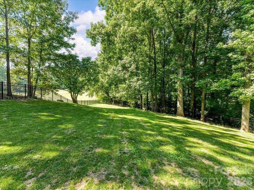 4725 Old Course Drive, Charlotte, NC 28277.  MLS# CAR4384171, YatesRealty ID 28405. The expansive, tree-lined backyard offers exceptional privacy, a fully fenced setting, and picturesque views extending toward the neighboring golf course.