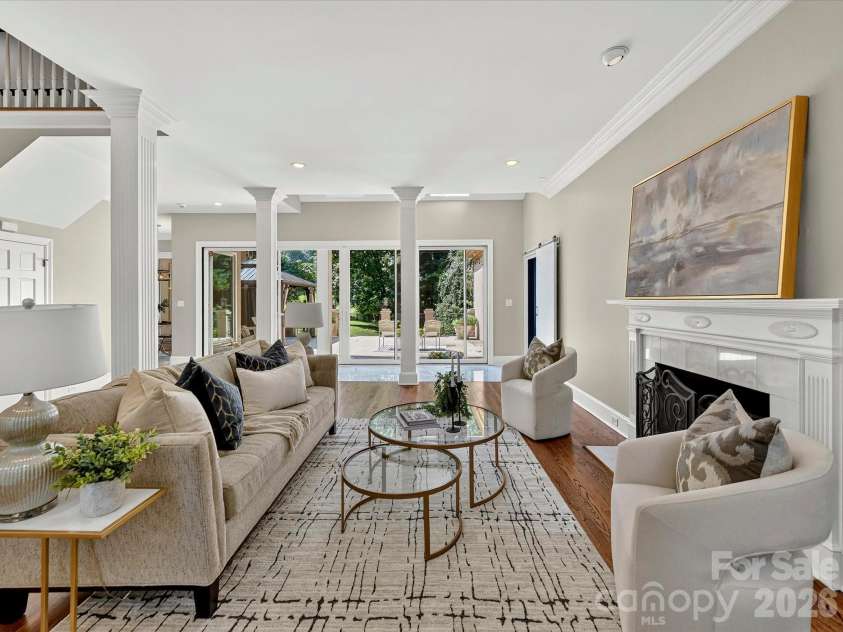 4725 Old Course Drive, Charlotte, NC 28277.  MLS# CAR4384171, YatesRealty ID 28405. The impressive Great Room showcases soaring ceilings, elegant architectural columns, a cozy fireplace, expansive gathering space, and seamless access to the outdoor living areas, creating the perfect setting for ever