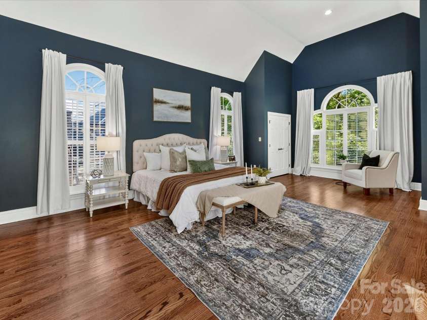 4725 Old Course Drive, Charlotte, NC 28277.  MLS# CAR4384171, YatesRealty ID 28405. The luxurious primary suite offers soaring vaulted ceilings, elegant arched windows, abundant natural light, generous space for a private sitting area, and a serene retreat designed for comfort and relaxation.