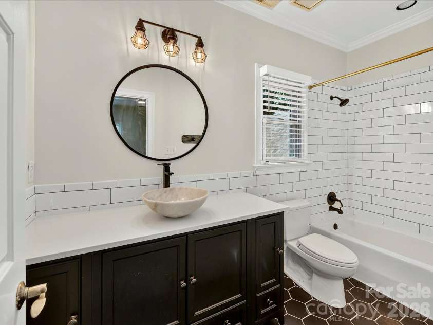 4725 Old Course Drive, Charlotte, NC 28277.  MLS# CAR4384171, YatesRealty ID 28405. The private ensuite bath features a stylish vanity, modern vessel sink, classic subway tile tub and shower, and designer finishes that blend comfort with contemporary appeal.