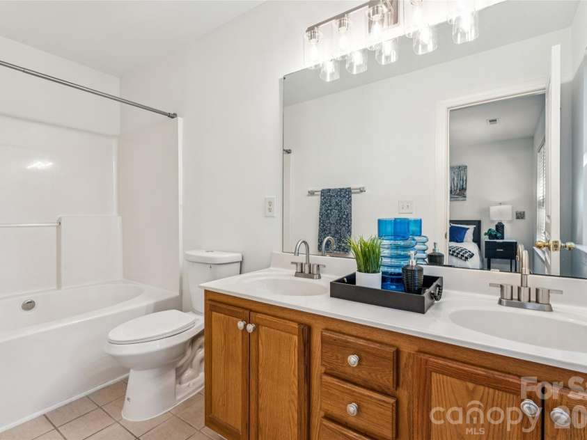 6333 Royal Celadon Way, Charlotte, NC 28269.  MLS# CAR4385329, YatesRealty ID 28493. Master bathroom featuring a new energy-efficient toilet, double vanity with updated faucets, and modern light fixtures.