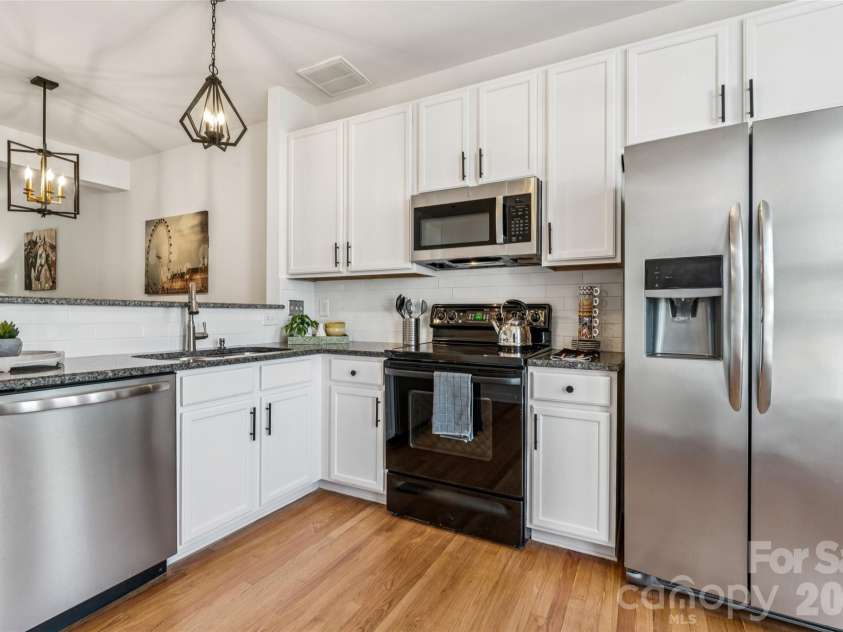 6333 Royal Celadon Way, Charlotte, NC 28269.  MLS# CAR4385329, YatesRealty ID 28493. The kitchen features granite countertops and a timeless white subway tile backsplash, creating a classic aesthetic that seamlessly complements any decor style for the new homeowner.