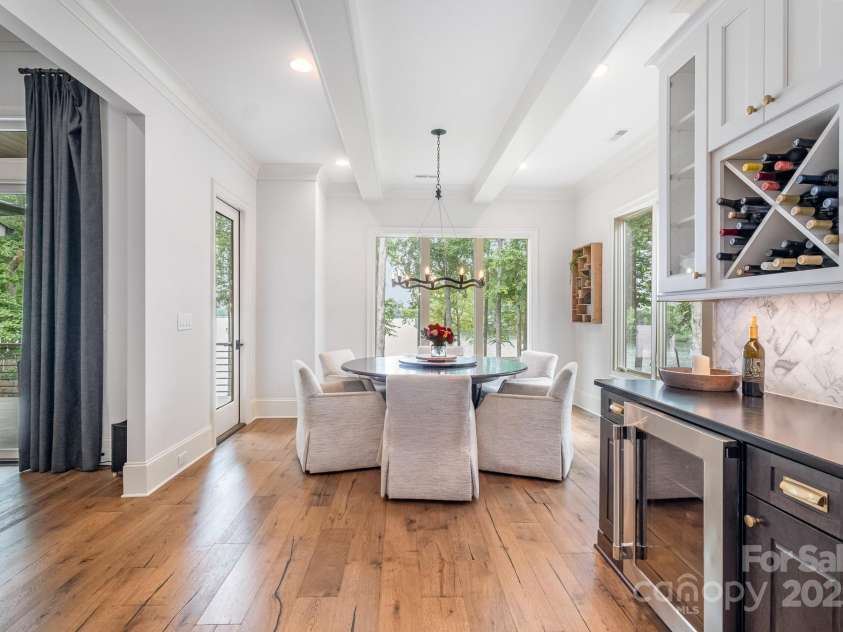 708 Amalfi Drive, Davidson, NC 28036.  MLS# CAR4281253, YatesRealty ID 28511. Dining area with access to covered terrace features Curry & Co. serpentine ring chandelier.