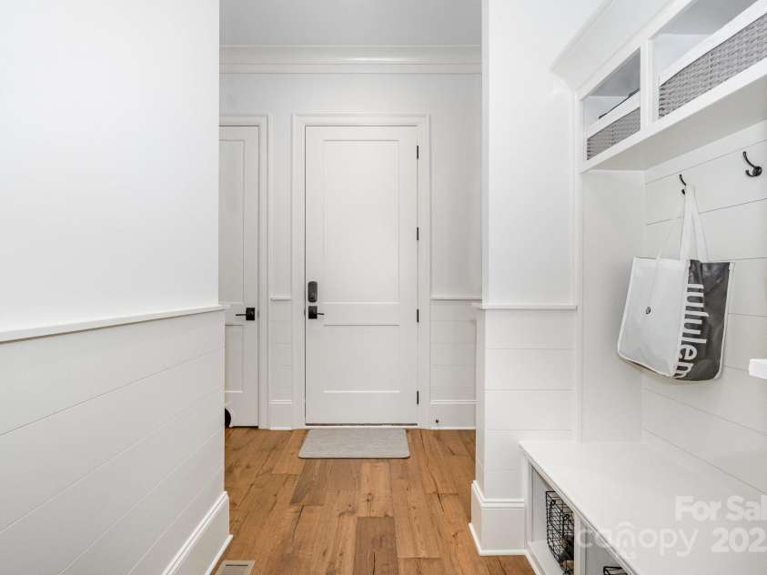708 Amalfi Drive, Davidson, NC 28036.  MLS# CAR4281253, YatesRealty ID 28511. Drop zone tucked away off garage displays nickel gap siding wainscoting with built-in bench and cubbies.