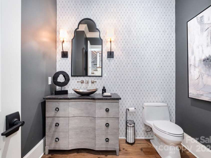 708 Amalfi Drive, Davidson, NC 28036.  MLS# CAR4281253, YatesRealty ID 28511. Main level powder room features a custom vanity with vessel sink and Carrara Marble tile accent wall.
