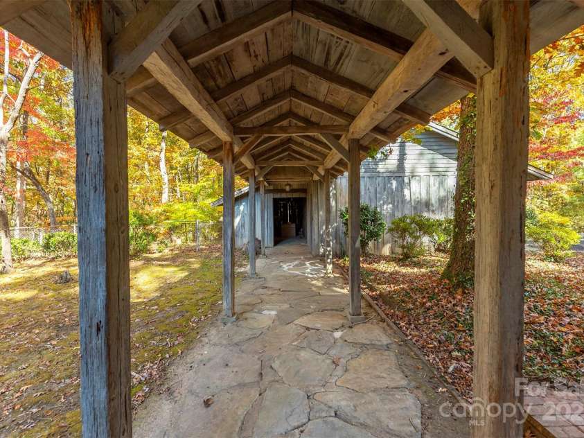 102 Weaver Mill Road, Columbus, NC 28722.  MLS# CAR4211548, YatesRealty ID 2852. The corridor leading from the house to the barn